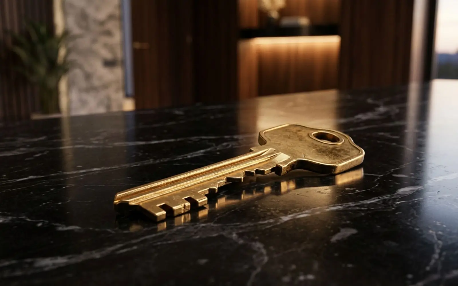 Gold house key on black marble